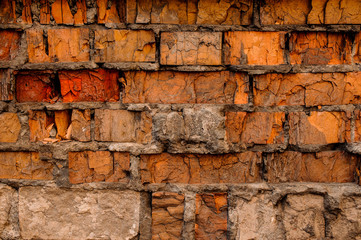 Cracked concrete vintage orange, red and beige bricks wall background