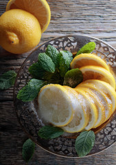 Lemon slices with sugar and mint leaves.