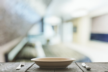 empty plate with fork and knife on wooden table