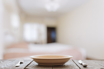 empty plate with fork and knife on wooden table