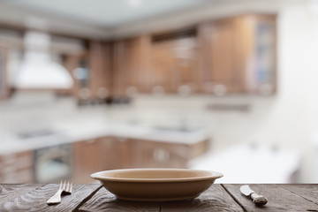 empty plate with fork and knife on wooden table