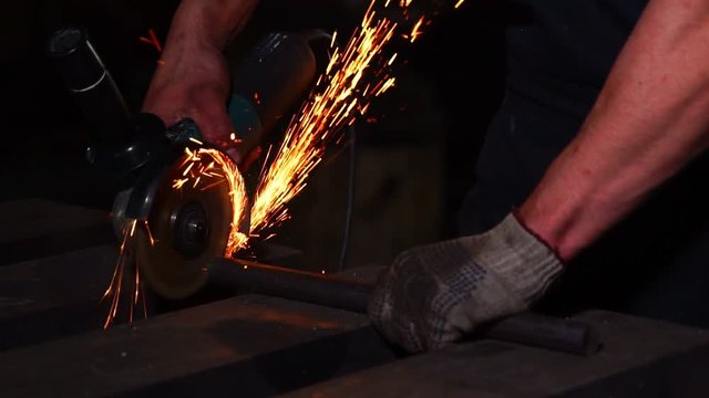 closeup on electric saw and hands of worker with sparks. man working with grinder, close up on tool, sparks fly, real situation picture.