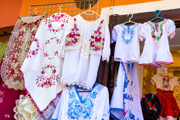 Beautiful bright ethnic shirts and tablecloths with traditional Hungarian embroidery in a street store