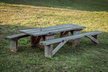 Old wooden table with benches in nature.