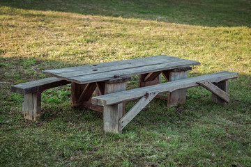 Fototapeta premium Old wooden table with benches in nature.