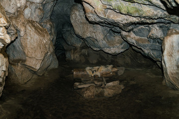Beautiful cave. View from inside dark dungeon. Textured walls of cave. Background image of underground tunnel. Dampness inside cave. Dwelling of primitive cave people.