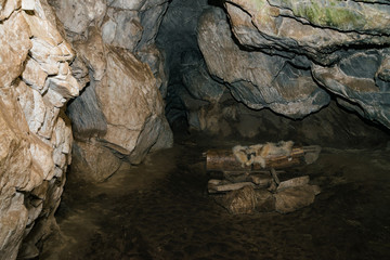 Beautiful cave. View from inside dark dungeon. Textured walls of cave. Background image of underground tunnel. Dampness inside cave. Dwelling of primitive cave people.