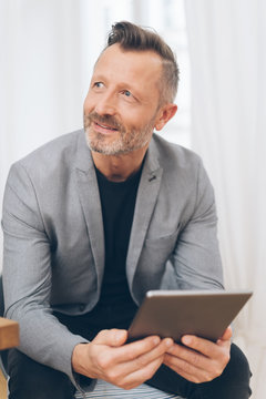 Smiling mature man using digital tablet