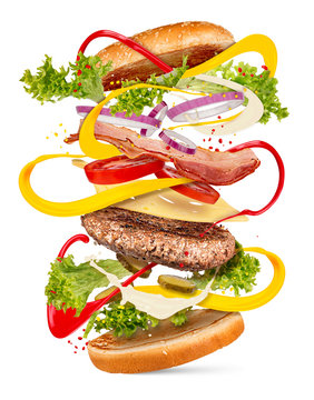 Naklejki creative cheeseburger fast food explosion hamburger ingredients falling concept isolated on white background