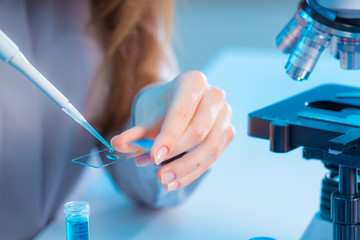 female technician take sample on microscope slide