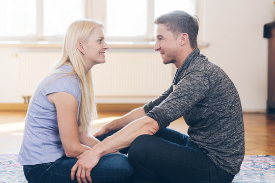 Blonde woman with sitting in front of man at home