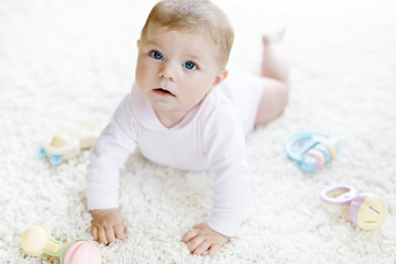 Cute baby girl playing with colorful pastel vintage rattle toy