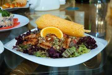 Salad with meat, orange, cabbage, rucola and toast, background, close-up
