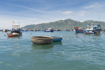 Obraz premium fishing boats, junks in the sea bay near the island of Vinperl, amidst the islands covered with tropical vegetation and blue sky, Vietnam