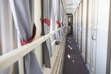 Interior of the corridor inside the compartment car of the passenger train for travel.