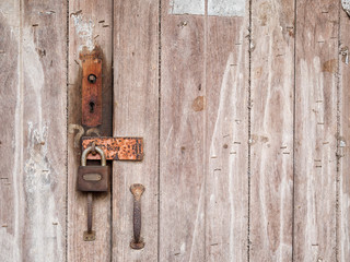 old lock on the wooden door in front of old farmhouse at rustic countryside