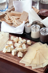 Cheese on the wood plate with empty wine glasses