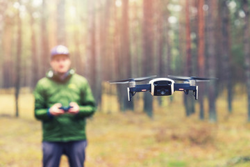 man flying drone in the woods - obrazy, fototapety, plakaty