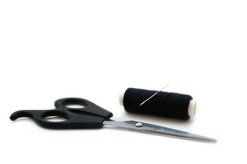 Scissors, needle and sewing thread coil on white background.