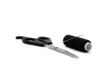 Scissors, needle and sewing thread coil on white background.