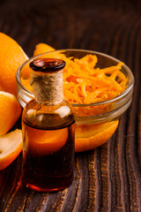 orange essential oil on a wooden background