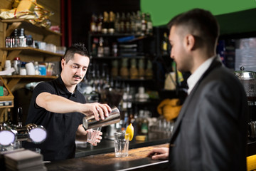 Male barista making cocktail