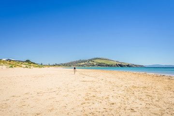 Fototapeta na wymiar Cremorne Beach, South-Arm Peninsula, Tasmania, Australia: Relaxing quiet fishing day at a sandy beach river ocean coastline perfect sunny summer weather and blue water green mountains in background