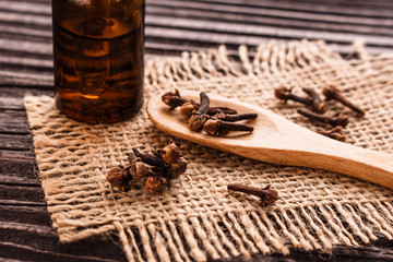 essential oil of cloves on a wooden rustic background
