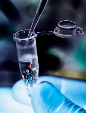 Scientist pipetting sample into vial with molecular structure of formula
