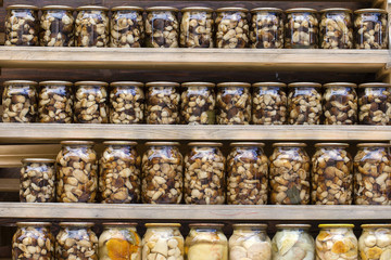 Porcini mushrooms marinated in glass jars in the local market. Carpathians, Ukraine
