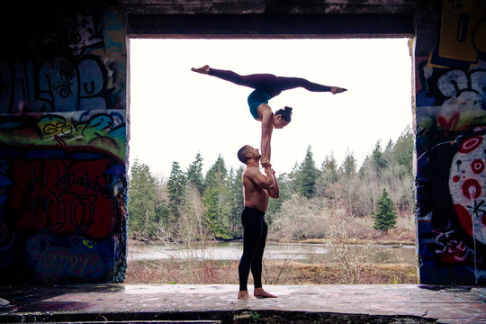 Couple practising acroyoga on outdoor stage