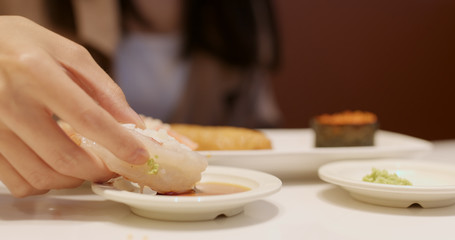 Obraz na płótnie Canvas Woman having Japanese sushi in restaurant