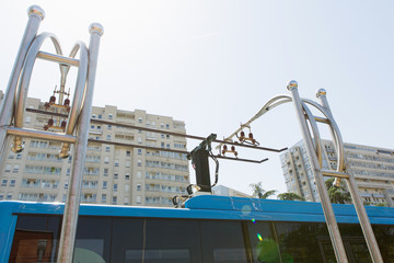 Electric bus at a stop is charged by pantograph