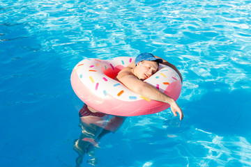 a drunk guy swims on inflatable circle in the pool. travel of a Russian tourist
