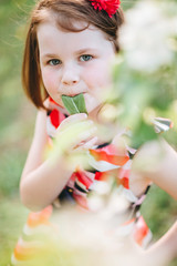 Portrait of a beautiful girl in a garden near a blossoming apple tree. Beautiful back light and happy baby in the garden