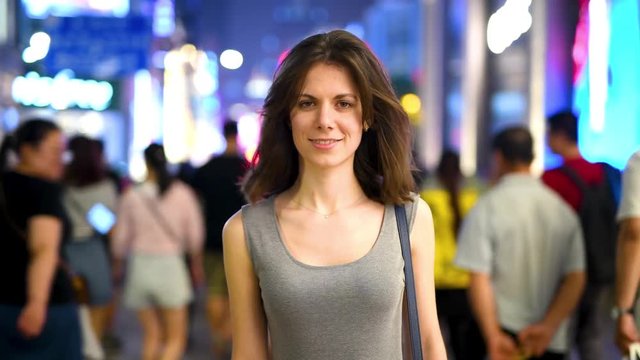 Young attractive woman standing in the crowded street in the center of Shanghai, time lapse video with smashed people in the crowd