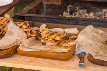 Pieces of roasted meat grilled on a rustic background - rest, picnic outdoors
