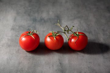 Red fresh juicy tomatoes on a stone table.