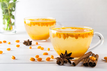Natural Berry tea with a fresh sea-buckthorn berries and cinnamon sticks, anise stars