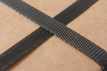 Closeup of a brown cardboard with black strapping