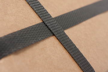 Closeup of a brown cardboard with black strapping