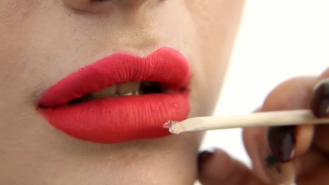 Woman doing makeup lips close up
