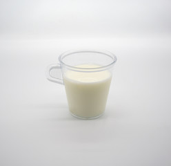 Fresh milk or soil milk in clear plastic cup with handle isolated on white