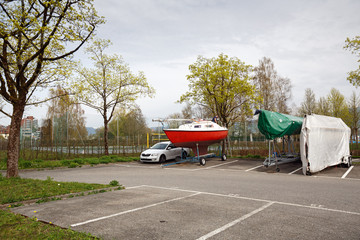 Boat trailers covered with tarpaulin in the car parking lot in the town of Cham, canton of Zug, Switzerland, Europe.