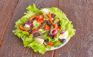 salad from fresh vegetables in a plate on a table, selective focus