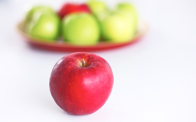 Red apple lies on a white table
