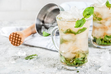Cold summer beverage, mint julep cocktail drink, grey stone background copy space