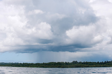 A raincloud pours on the horizon