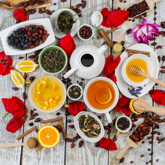 Various leaves of tea and spices on wooden background