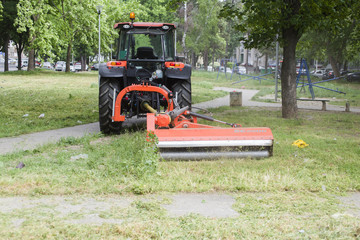 Tractor with lawn mowing grass in a Public Park